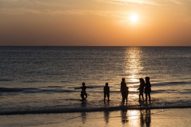 Langkawi, Malezya, 21 Aralık 2017: Gün batımında Langkawi plajda aile banyoları