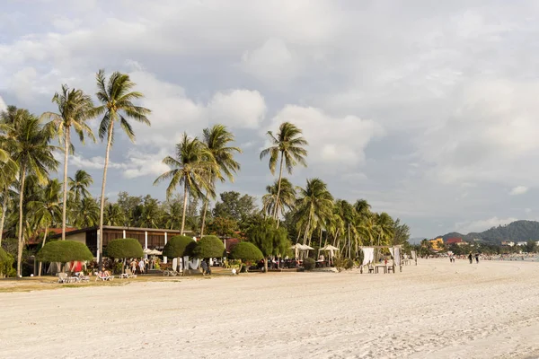 Langkawi, Malajsie, 21 prosince 2017: Bílá písečná pláž Langkawi s palmami a bungalovy v pozadí — Stock fotografie