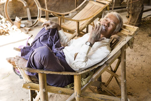 Bagan, Myanmar, December 27, 2017:  Senior man recovers in an armchair — Stock Photo, Image