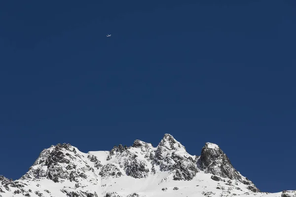 Schneebedeckter, frischer weißer Berggipfel mit Flugzeug in den Schweizer Alpen — Stockfoto