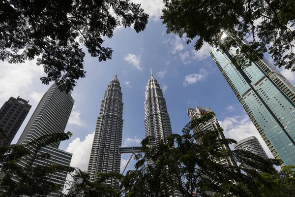 KUALA LUMPUR, MALAYSIA, 13 de dezembro de 2017: As Torres Gêmeas Petronas com árvores em primeiro plano — Fotografia de Stock