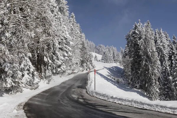 Route de montagne traversant un paysage frais et enneigé en Suisse — Photo