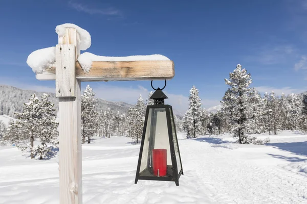 Un sentier de randonnée hivernal balisé par une lanterne traverse un paysage frais et enneigé en Suisse — Photo