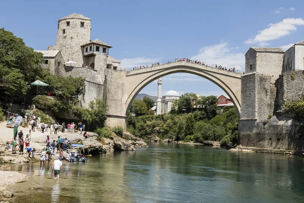 Mostar, Bosna a Hercegovina, 15 července 2017: turisté těšit pohled historický obloukový most přes řeky Neretvy do Mostaru na krásný letní den — Stock fotografie