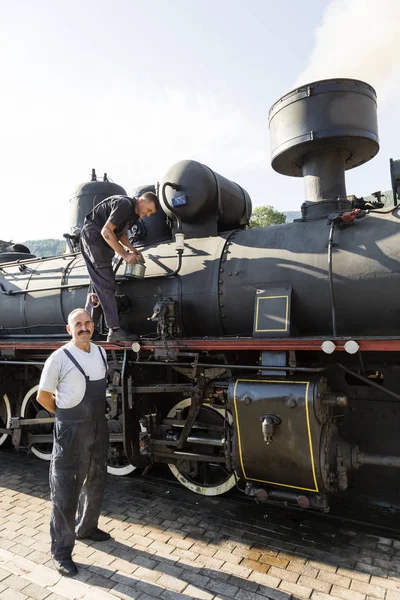 Sargan Vitasi, Servië, juli 17 2017: Twee machinisten voorbereiden op de stoomlocomotief de reis. Vanaf hier begint de zogenaamde "Sargan Eight" smalspoor erfgoed railway naar Mokra Gora. — Stockfoto