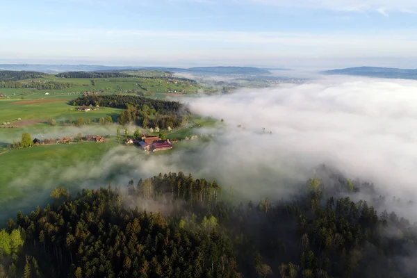 Flygfoto över det kuperade landskapet i centrala Schweiz på en vacker vårmorgon med vissa morgondimman — Stockfoto