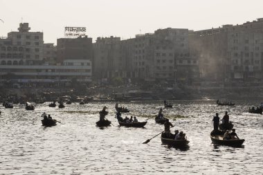 Dhaka, Bangladesh, 24 Şubat 2017: Arkadan aydınlatmalı çekim bir taksi olarak kullanılan küçük ahşap teknelerin Dhaka Bangladeş'te Buriganga Nehri üzerinde işlem yapar