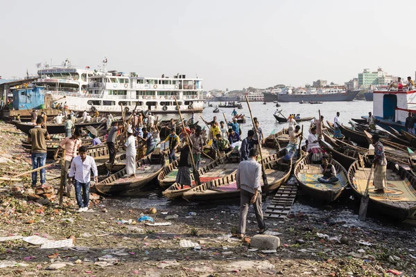 Dhaka, Bangladesh, 24 de febrero de 2017: Los hombres esperan a los pasajeros en sus pequeños botes de remos en Sadarghat del río Buriganga en Dhaka Bangladesh — Foto de Stock