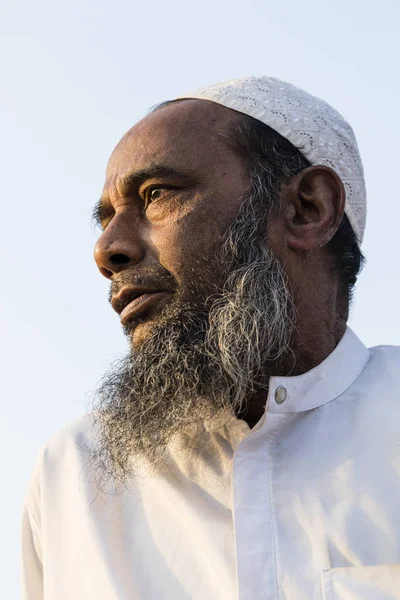 Dhaka, Bangladéš, 24 února 2017: Staré muslimské s vousy a čepici vzít zespoda světle modré obloze — Stock fotografie