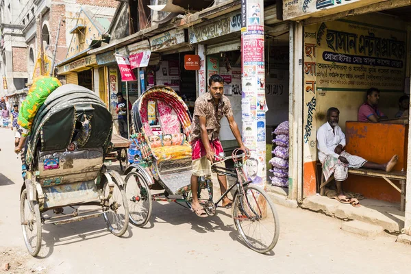 Dhaka, Bangladesz, 24 lutego 2017: Trishaw kierowca prowadzi w dół ulicy handlowej Sadargat molo w Dhaka, Bangladesz — Zdjęcie stockowe