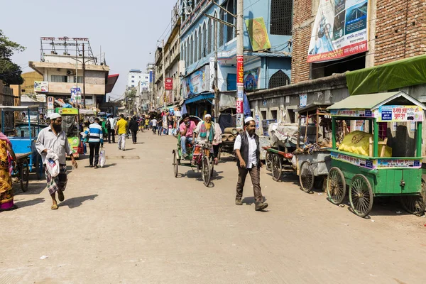 Dhaka, Bangladesh, 24 de fevereiro de 2017: motorista de Trishaw e residente ao longo da rua comercial suja no Sadargat Pier em Dhaka, Bangladesh — Fotografia de Stock