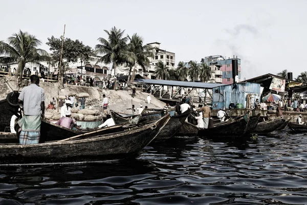 Dhaka, Bangladesh, 24 de febrero de 2017: Los hombres esperan a los pasajeros en sus pequeños botes de remos en Sadarghat del río Buriganga en Dhaka Bangladesh (Foto Vintage ) — Foto de Stock