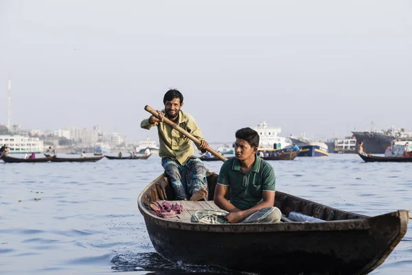 Dhaka, Bangladesh, February 24 2017: Wooden taxi boat with passengers and a cargo ship in background on the Buriganga River in Dhaka Bangladesh — Stock Photo, Image