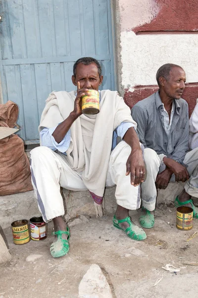 Hamd ELA, Etiopia, luty 23 2015: etiopskie mężczyźni siedzą na zewnątrz na ulicy mówienia i picia lokalnego napoju ze starych cyny puszki — Zdjęcie stockowe