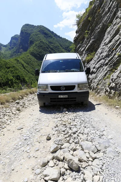 Theth, Albania, 6 de julio de 2019: Autobús de camping en un camino de tierra en el campo con bosques verdes en los Alpes Dináricos del norte en Albania — Foto de Stock
