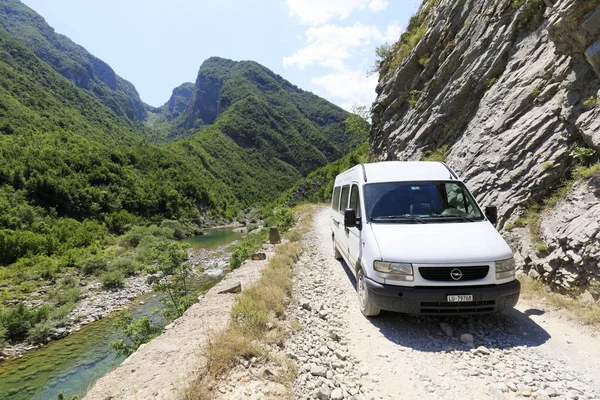 Theth, Albania, 6 de julio de 2019: Autobús de camping en un camino de tierra en el campo con bosques verdes en los Alpes Dináricos del norte en Albania — Foto de Stock