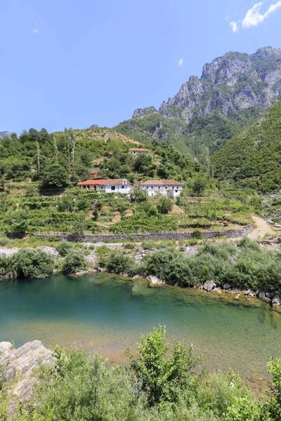 Fiume cristallino con una tipica casa albanese nelle Alpi Dinariche dell'Albania — Foto Stock