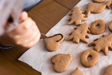 Dekorasyon zencefilli kurabiye üzerinde yakın yapma çocuk. Zekâ pişirme