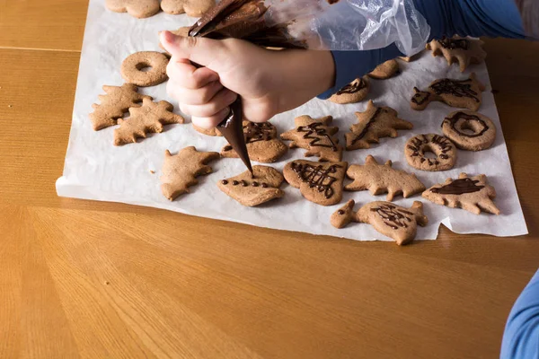 Kid making decoration on gingerbread cookie close up. Baking wit — Stock Photo, Image