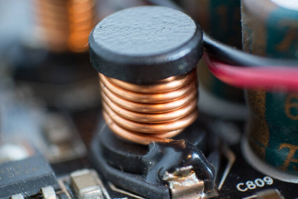 Электролитический конденсатор и проводник, видимые на печатном диске
