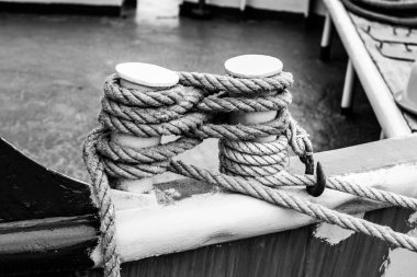 Cleat on the stern of a boat with a white rope. clipart