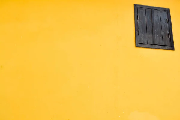 Yellow wall with wooden brown  window. Abstract composition