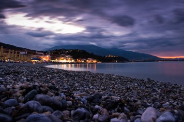 Çakıl kıyı şeridi görünümü'nde hafif günbatımı şaşırtıcı gece deniz manzarası, 