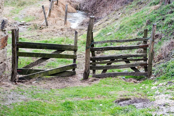 Um portão fechado em uma cerca de madeira em uma estrada da aldeia . — Fotografia de Stock