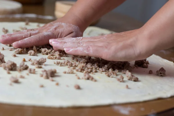 Frau macht Teig mit Fleisch zu Hause — Stockfoto