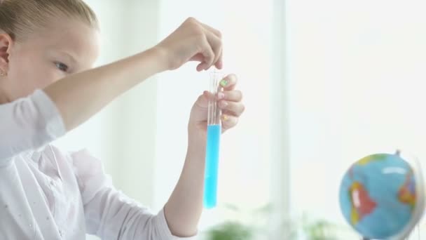 Chica haciendo un experimento de química. Chica sentada en un escritorio. Colegiala . — Vídeos de Stock