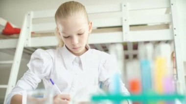Kız bir masada oturuyor ve bir şeyler yazıyor. Schoolgirl