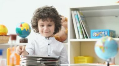 Çocuk ve kitap. Siyah kıvırcık saçlı sevimli çocuk kitabı açar