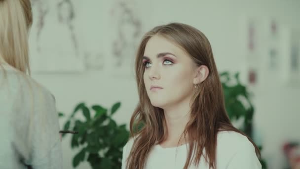 Modell ser upp, make-up artist måla nedre ögonlocket med hjälp av en borste. — Stockvideo