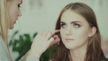 Makyaj işi. Makyaj sanatçısı ve model. Makyaj. Model yukarı bakar