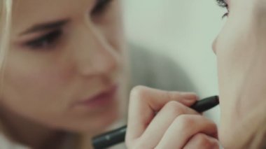 Ruj fırçası kullanan makyaj sanatçısı. Ruj trendy tonları