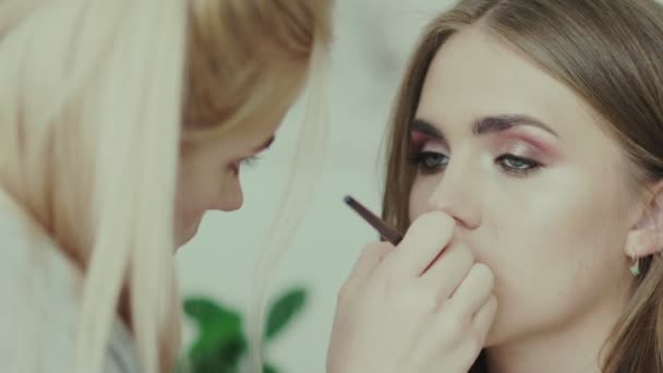 Make-up-Künstlerin mit Lippenstift-Pinsel. trendige Lippenstiftnuancen — Stockvideo
