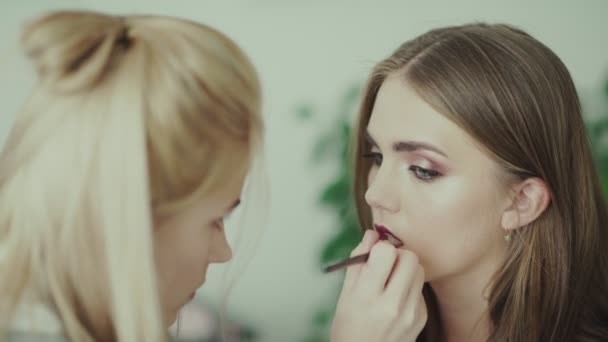 Make-up maluje rty krásné dívky. Model s rtěnky. — Stock video