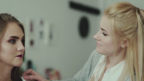 Make-up-Artist beendet Arbeit und glättet Haarmodell — Stockvideo