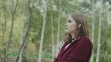 Boynunda boğulmalar ve ağaçların arka planında parlak makyajlı kız.