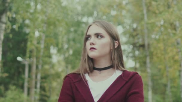 Retrato de una joven modelo en el bosque. Jersey marrón y labios brillantes . — Vídeo de stock