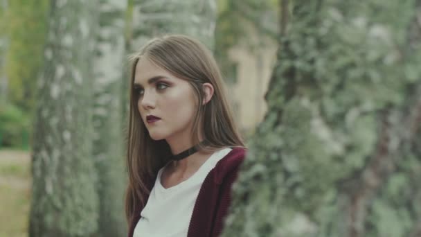 Retrato de una joven modelo en el bosque. Jersey marrón y labios brillantes . — Vídeo de stock