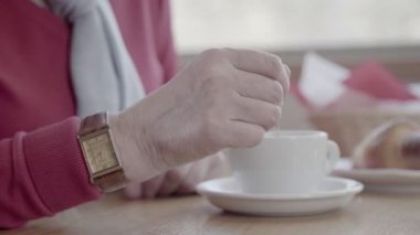 Olgun bir kadın el Close-Up şeker tatlı kaşığı kıpırdanırken.