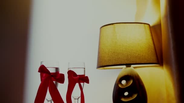 Romantisch interieur: dim verlichting, kaarsen, twee glazen van champagne — Stockvideo