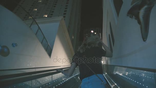 Emiratos Árabes Unidos, 2017: Mujer joven sube por la escalera mecánica . — Vídeo de stock