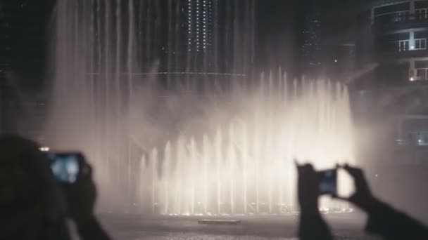 Personer titta på dansande fontäner och fotograferade på en mobiltelefon — Stockvideo