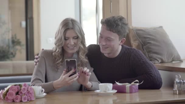 No casal de amor em um encontro em um café olhando um para o outro e sorrindo — Vídeo de Stock