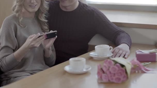 幸福的夫妇，在手机上看，笑在咖啡馆 . — 图库视频影像