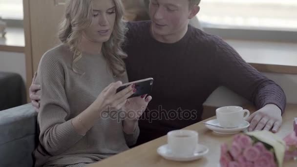 A timid young man talking to a woman in a cafe and smiling. — Stock Video