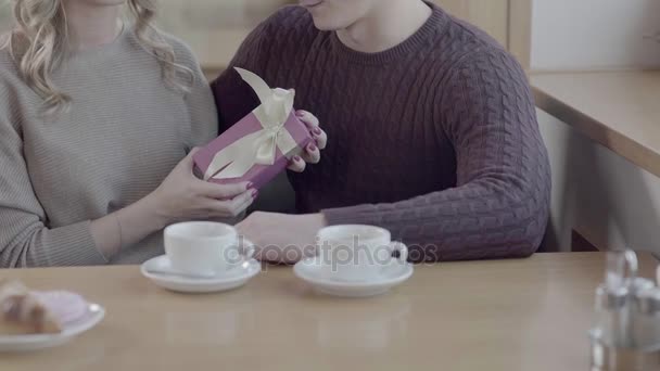 Beautiful girl holds a box with a gift from the boyfriend. He hugs her — Stock Video