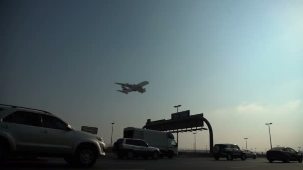 Het vliegtuig komt in het land op Dubai Airport en vliegen laag over weg — Stockvideo